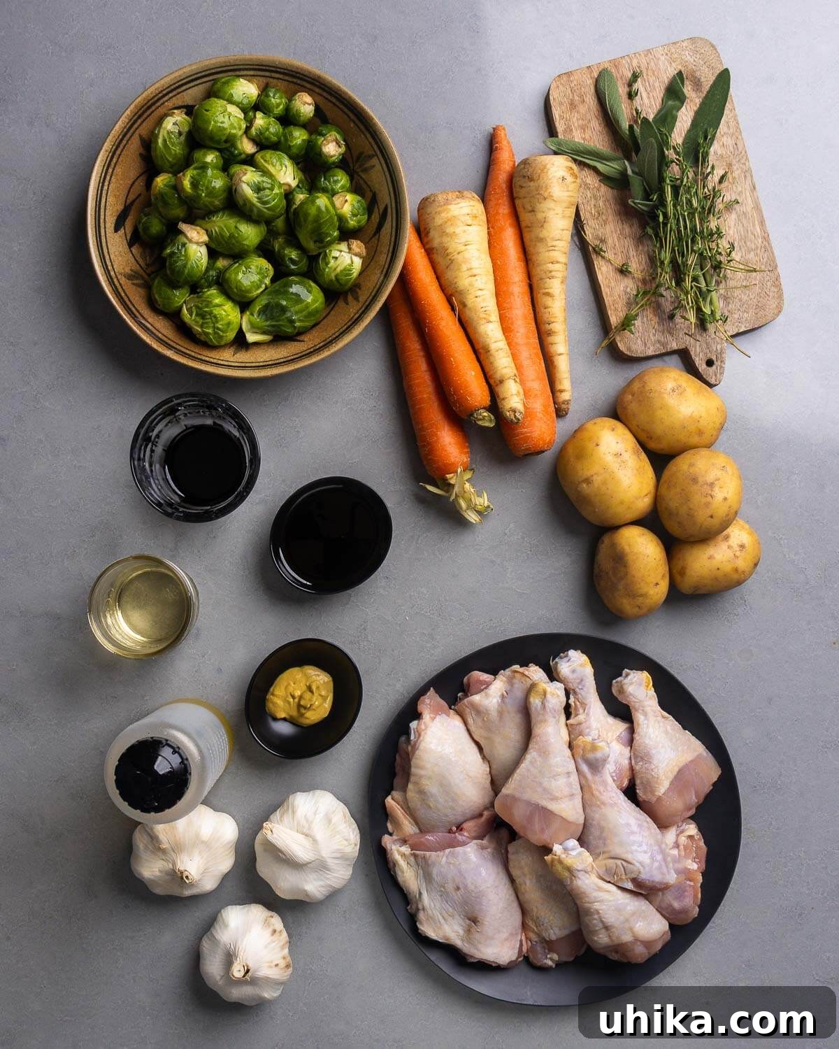 Maple Glazed Roast Chicken 4 Ingredients shown for maple roasted chicken: brussels sprouts, carrots, parsnips, sage, thyme, potatoes, balsamic vinegar, maple syrup, white wine, mustard, olive oil, garlic, and chicken thighs and legs.