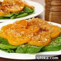 Roasted golden beet slices served on a bed of fresh spinach leaves, topped with warm shallot vinaigrette and cracked black pepper.