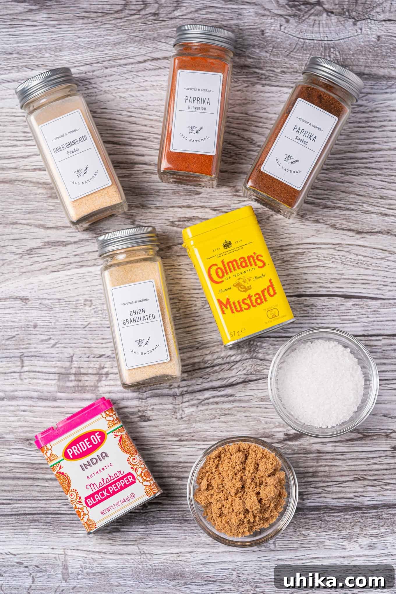 Effortless BBQ Flavor Blend 3 An overhead view of the ingredients for BBQ spice rub; sweet and smoked paprika, brown sugar, salt, granulated garlic and onion, pepper, and dry mustard.