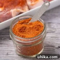 Effortless BBQ Flavor Blend 6 Homemade dry rub for pork chops in a glass jar with measuring spoon.