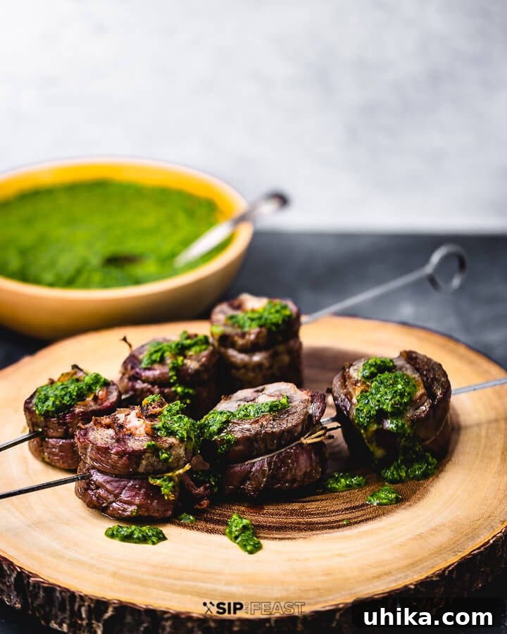 Skewered Steak Pinwheels with Homemade Salsa Verde Perfectly grilled and skewered flank steak pinwheels, garnished with fresh herbs and served with a side bowl of vibrant Italian salsa verde.