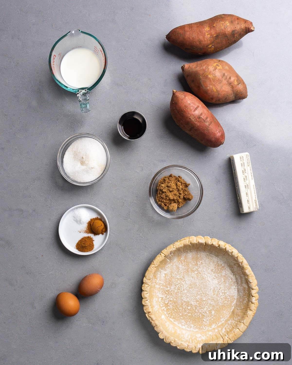 Velvet Sweet Potato Pie 4 Arrangement of sweet potato pie ingredients: milk, whole sweet potatoes, granulated sugar, vanilla extract, brown sugar, butter, cinnamon, nutmeg, salt, eggs, and an unbaked pie crust.