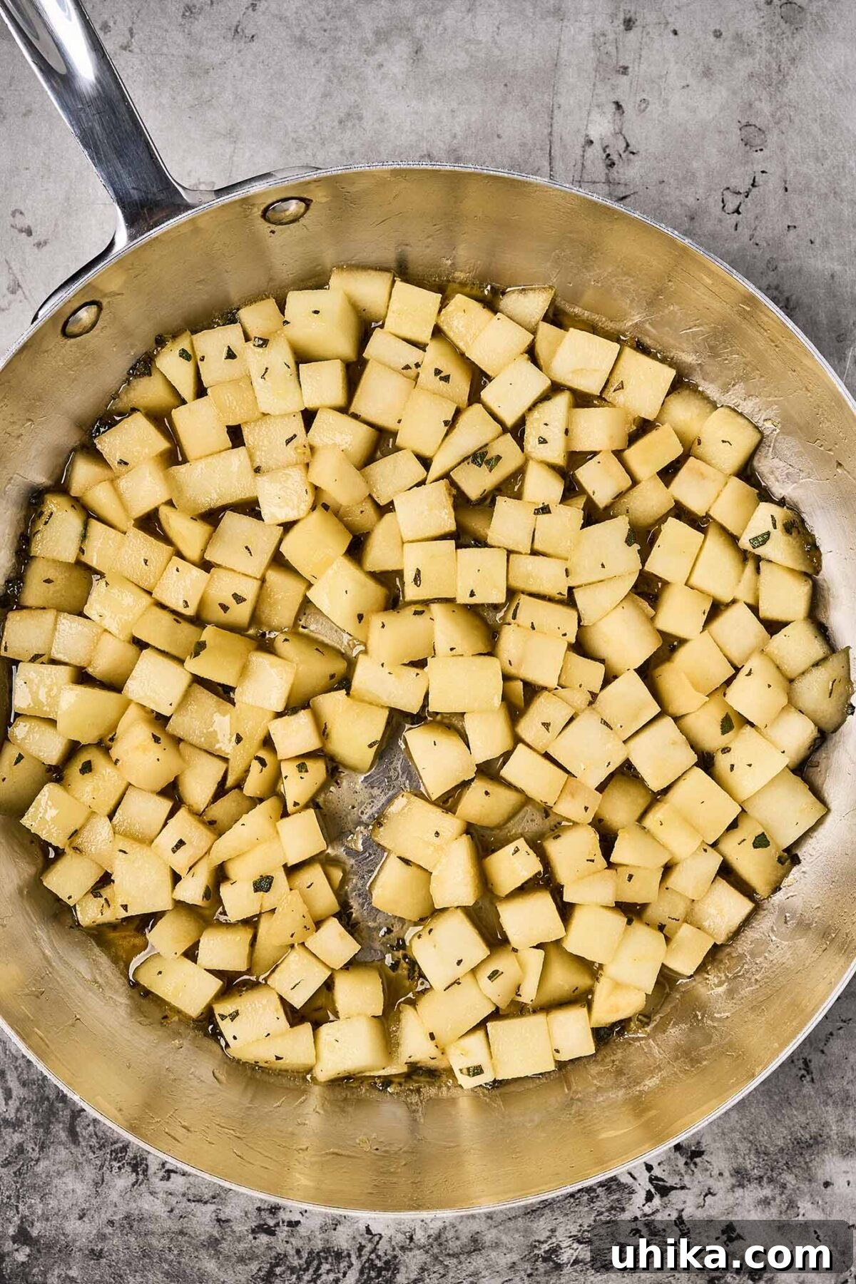 Caramelized Sweet Potato & Apple Gems 5 Second step in preparing sweet potatoes and apples - apples in a pan, cooking in butter with lemon juice, lemon, zest, honey and sage.