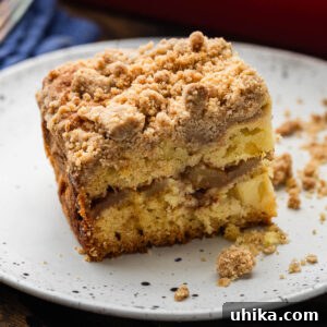 Slice of apple coffee cake on white plate.