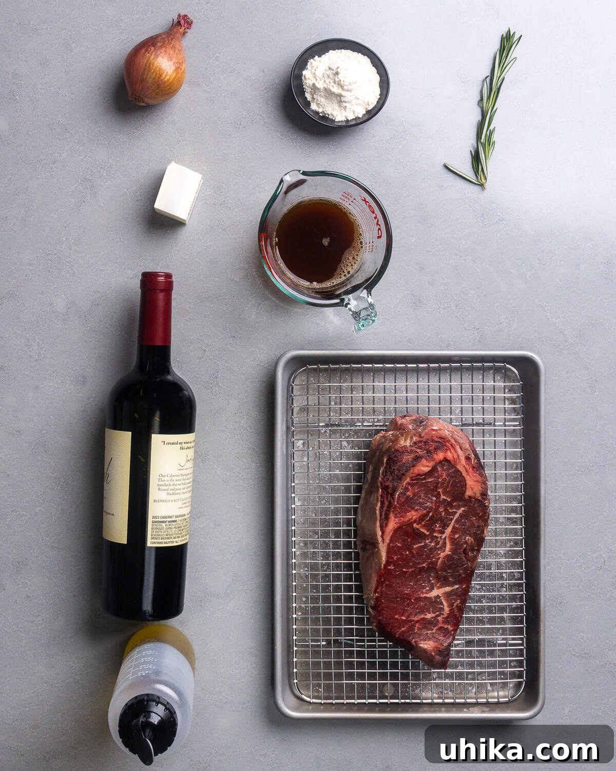 Decadent Ribeye with Red Wine Reduction 4 Ingredients for Ribeye Steak with Red Wine Sauce including shallot, butter, flour, beef stock, rosemary, red wine, olive oil, and a salted ribeye steak.
