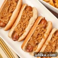 Hot dogs simmered in beer in buns topped with sauerkraut and served with seasoned French fries.