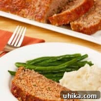 A perfectly sliced portion of old-fashioned meatloaf, ready to be served alongside classic sides.