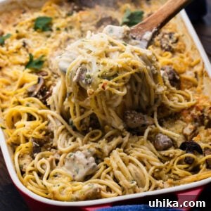Creamy Comfort Chicken Tetrazzini 7 Spoon scooping out a portion of chicken tetrazzini from baking dish.