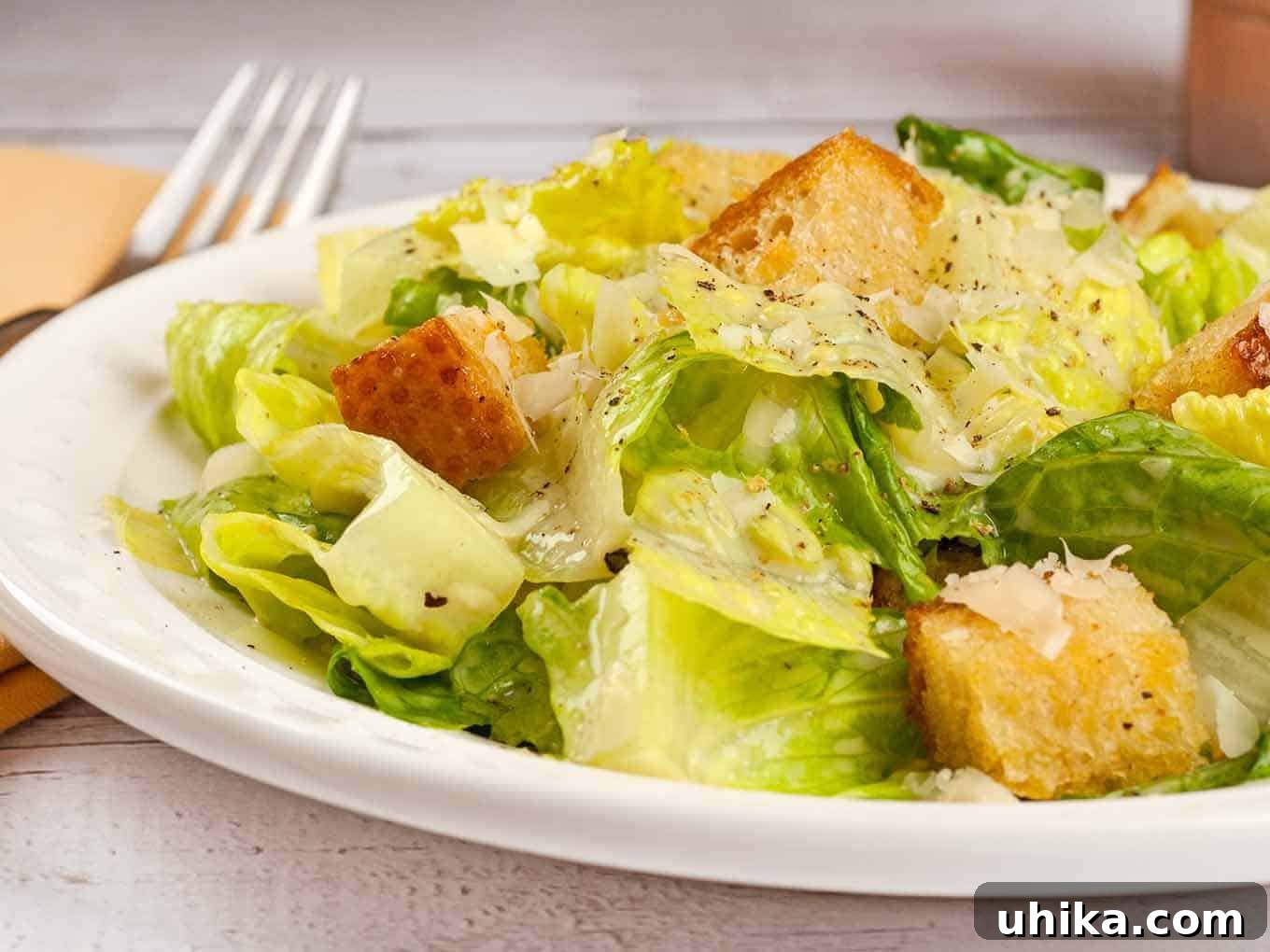 Regal Romaine Delight 3 A serving of easy-to-make Caesar salad topped with golden garlic butter croutons and a generous sprinkle of grated Parmesan cheese, ready to be enjoyed.