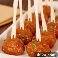 Close-up of a serving of Whiskey Glazed Cocktail Meatballs, garnished with fresh parsley.