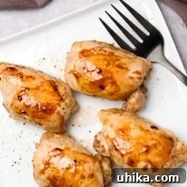 Succulent Oven-Roasted Boneless Chicken Thighs 5 A square serving plate containing four boneless, skinless chicken thighs, roasted and glazed with honey and balsamic vinegar.