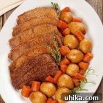 Pressure cooker pot roast served on a white platter with sliced beef, baby potatoes, and chunks of carrot, garnished with sprigs of thyme and rosemary on a rustic wooden table.