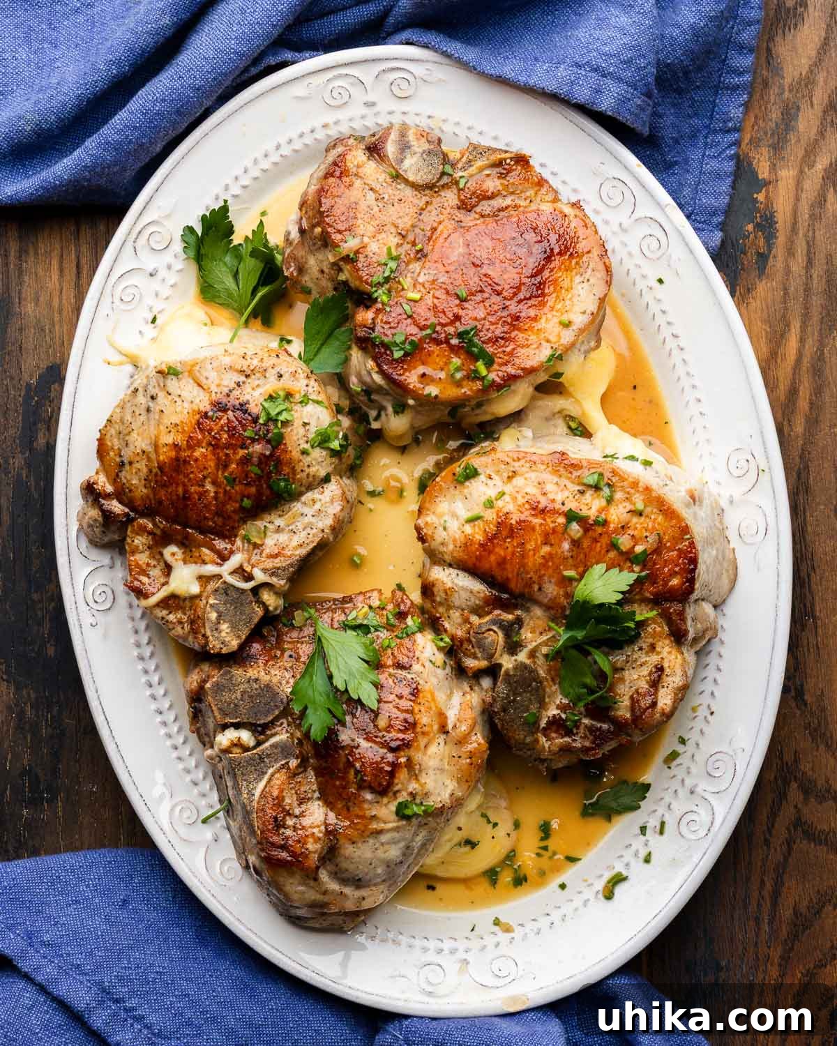 Creamy Fontina and Savory Prosciutto Stuffed Pork Chops 2 Plate of golden-brown Italian stuffed pork chops with prosciutto and fontina cheese, garnished with fresh parsley.