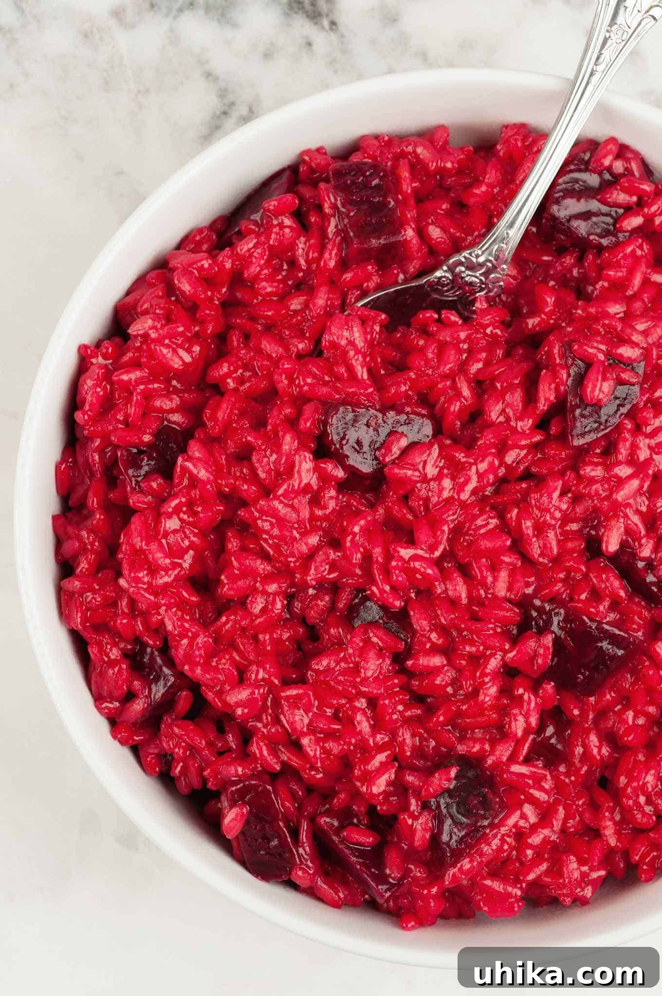 Crimson Beet Risotto 2 Roasted beet risotto in a white bowl, featuring creamy rice with vibrant red color and chunks of tender beet.