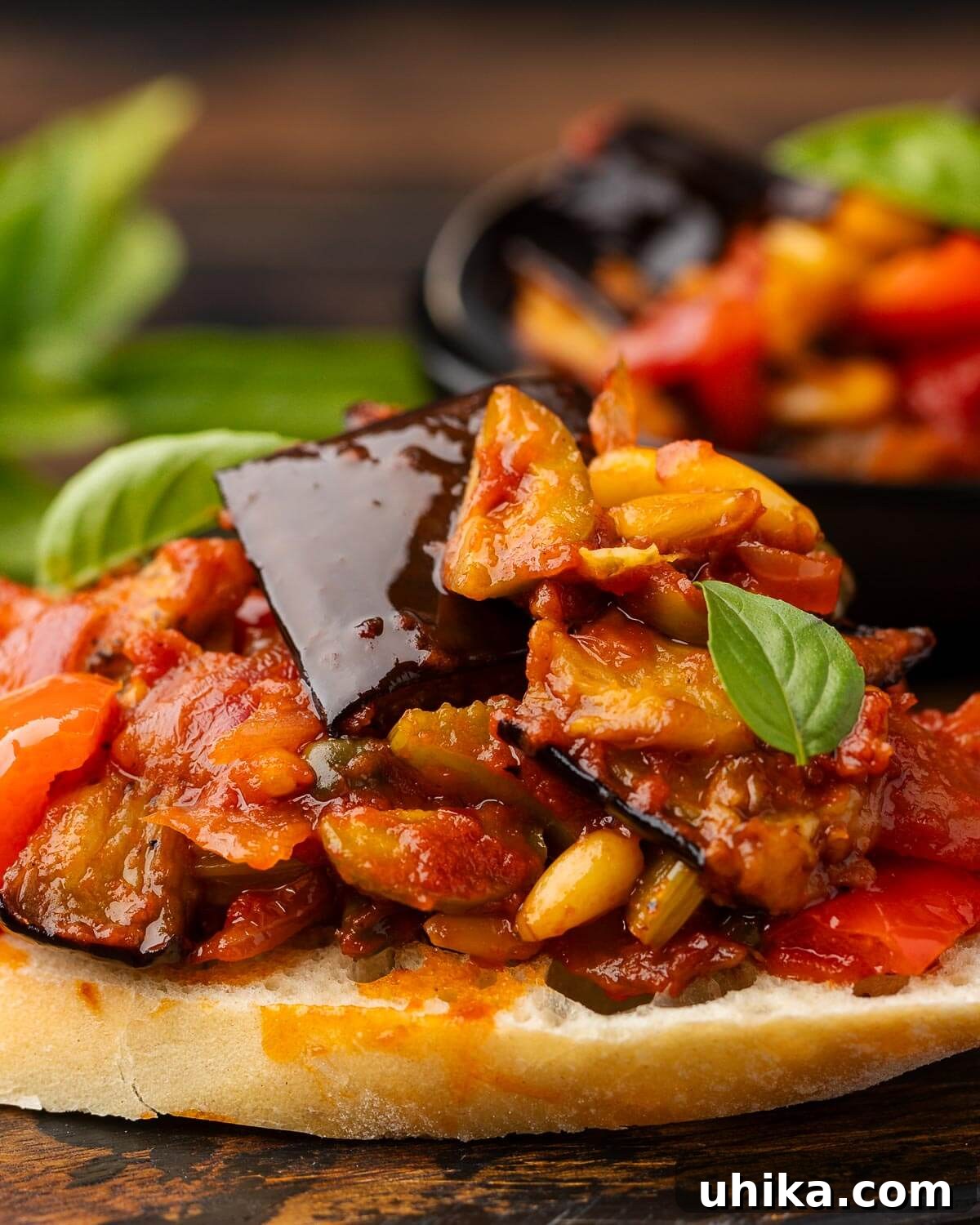 Close-up shot of homemade eggplant caponata generously spread onto crispy crostini, garnished with fresh parsley.