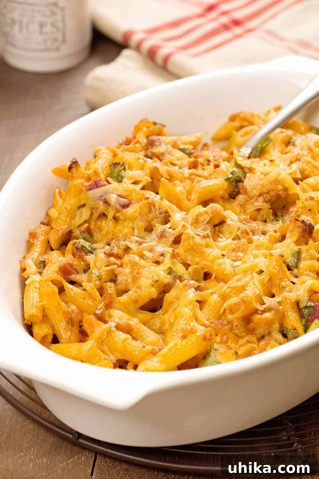 Smoky BBQ Chicken Pasta Delight 2 Baked barbecue chicken pasta in a white casserole dish, topped with melted cheese.