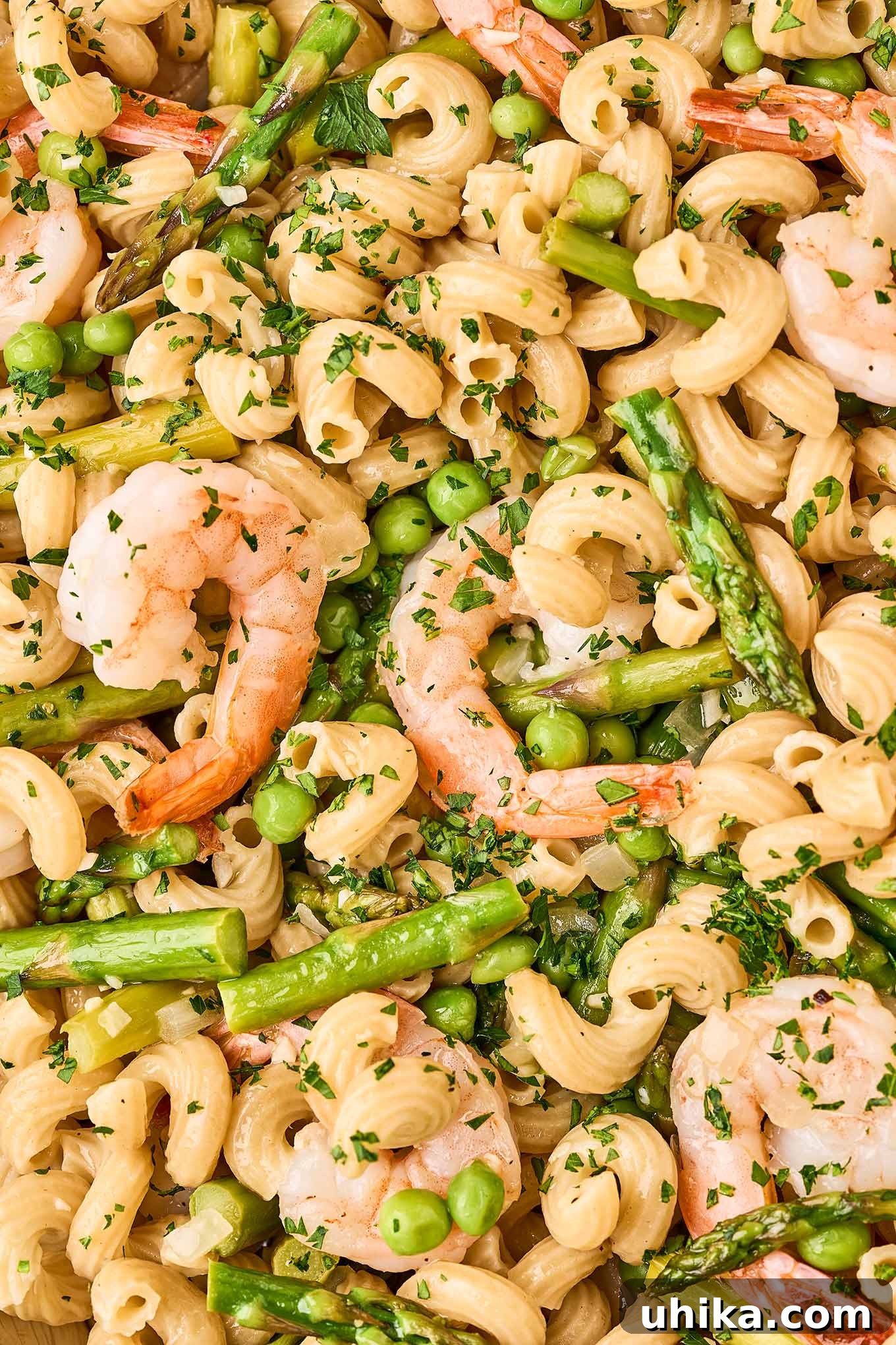 Vibrant Shrimp Primavera 8 A detailed close-up shot of Shrimp Pasta Primavera, showcasing the perfectly combined pasta with jumbo shrimp, vibrant asparagus, and sweet peas in a glossy white wine sauce.