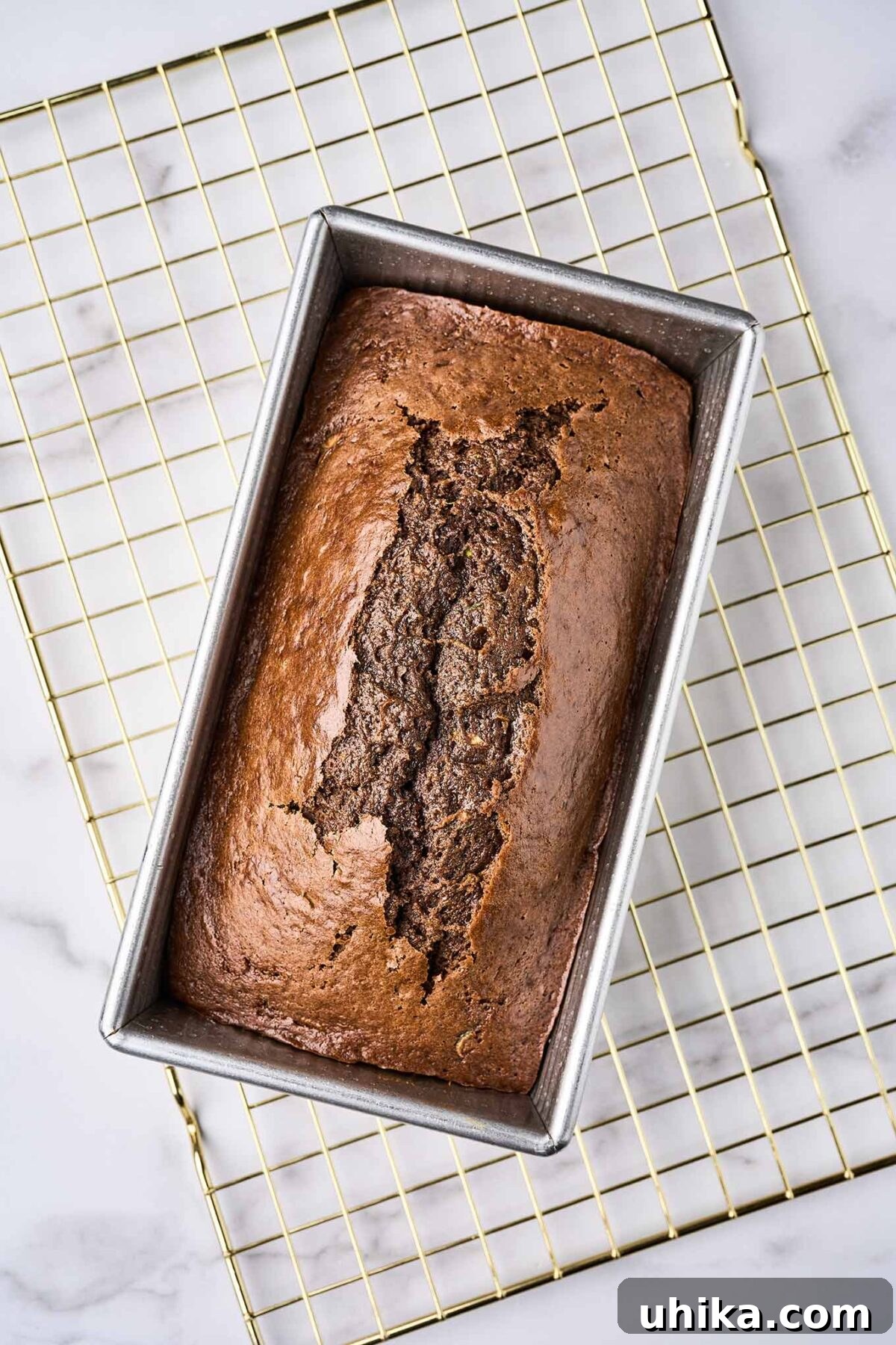 Double Chocolate Zucchini Loaf 7 A loaf of fresh-baked chocolate zucchini bread, cooling in the loaf pan on a wire cooling rack.