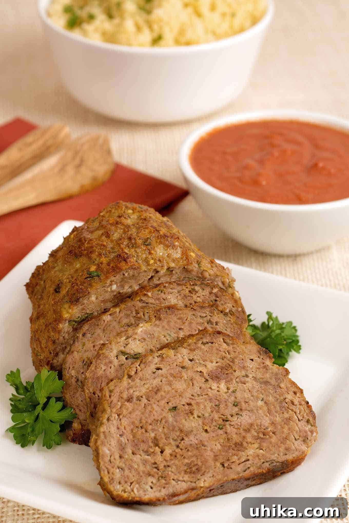 Harissa-Kissed Lamb Loaf 2 A perfectly sliced Moroccan-Spiced Lamb Meatloaf, garnished with fresh parsley, served with a tangy tomato-yogurt dipping sauce. This comforting dish brings vibrant North African flavors to a classic family favorite.