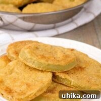 Crispy, cornmeal crusted, fried green tomatoes on a serving plate