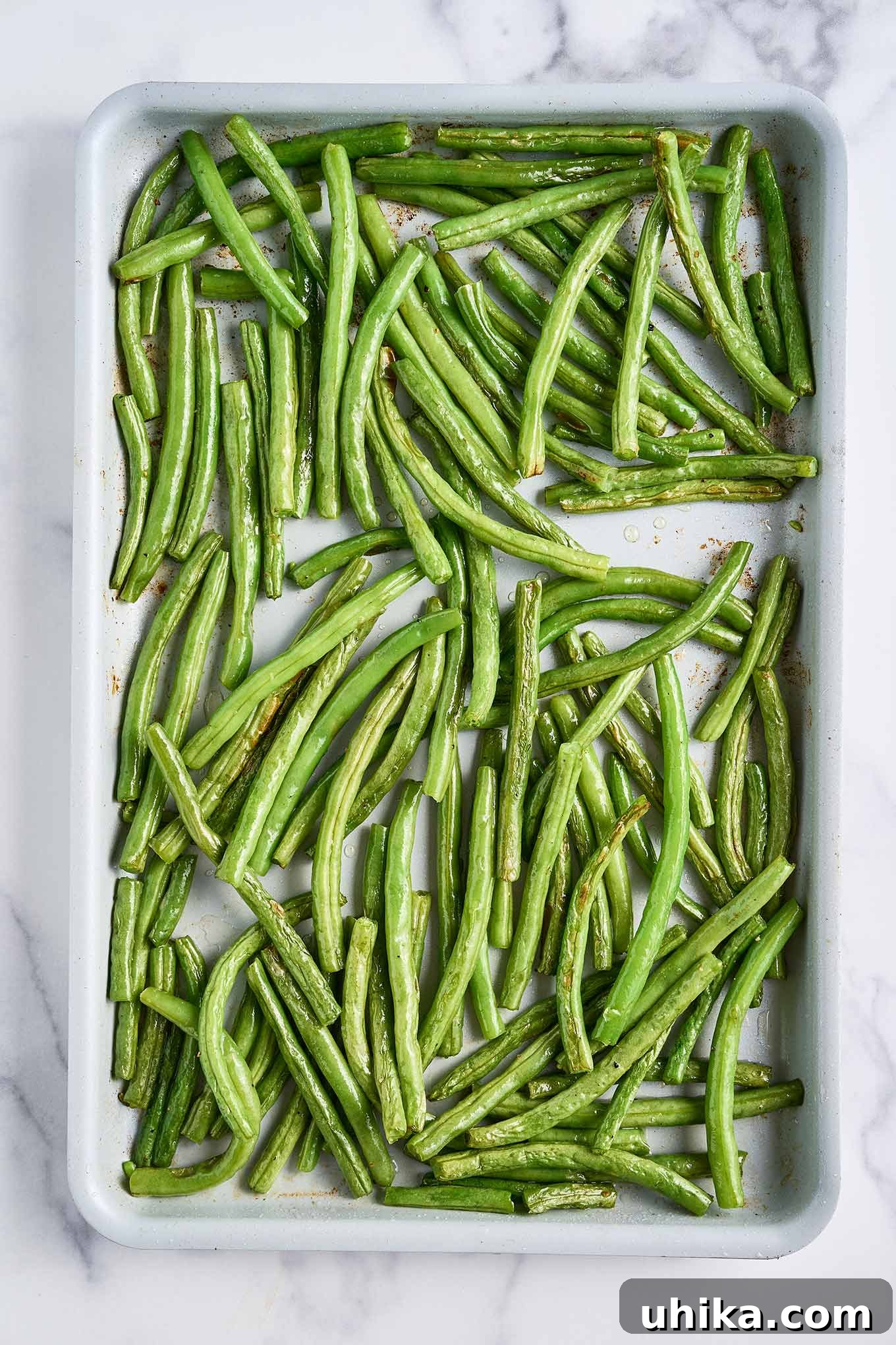 Crunchy Roasted Green Beans with Toasted Walnuts 3 Roasted green beans, tender and lightly browned, spread across a sheet pan, showing proper spacing for caramelization.