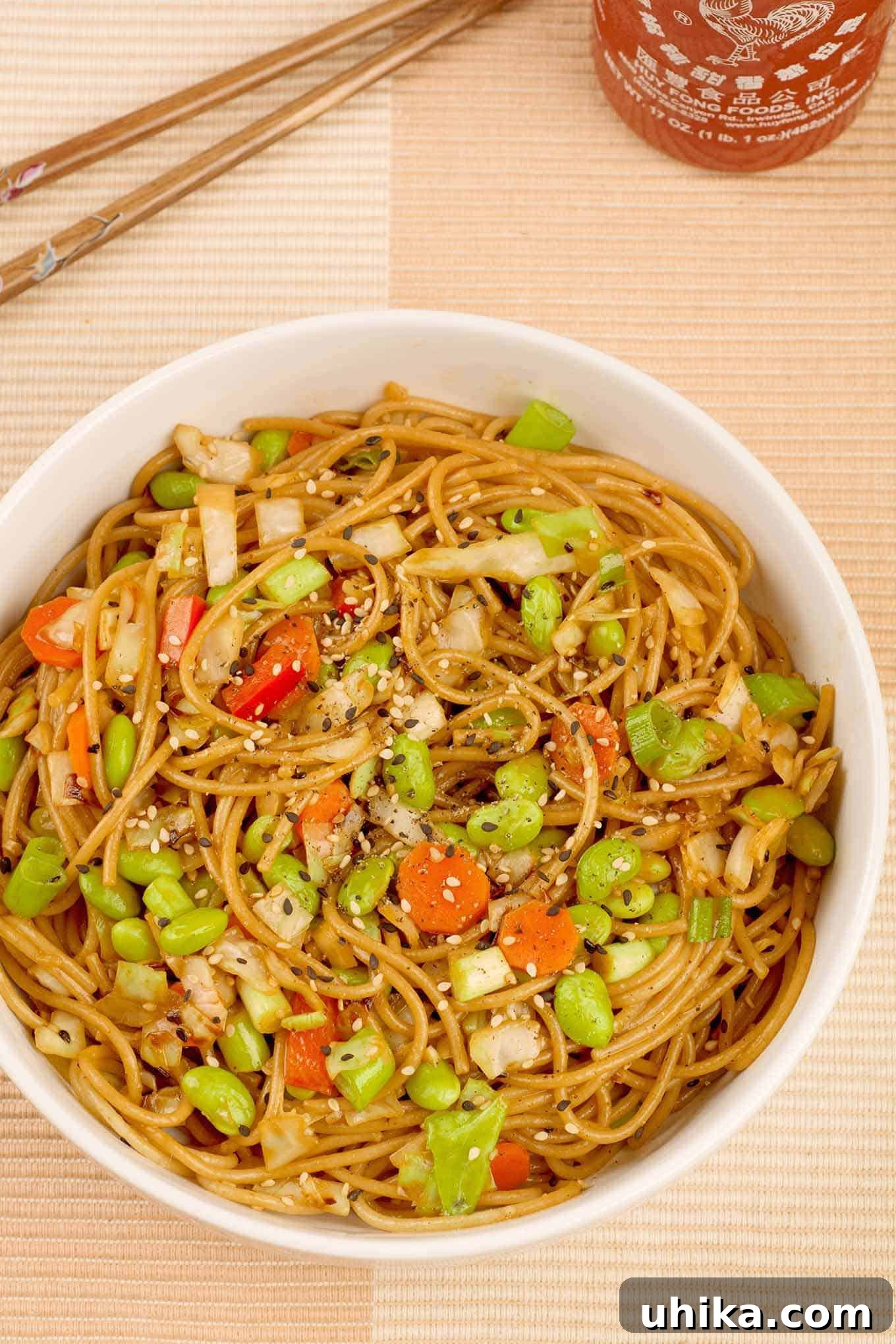 Savory Sesame Edamame Noodles 2 A vibrant bowl of whole wheat spaghetti tossed with bright green edamame, crisp stir-fried cabbage, toasted sesame seeds, and a rich, light peanut sauce.