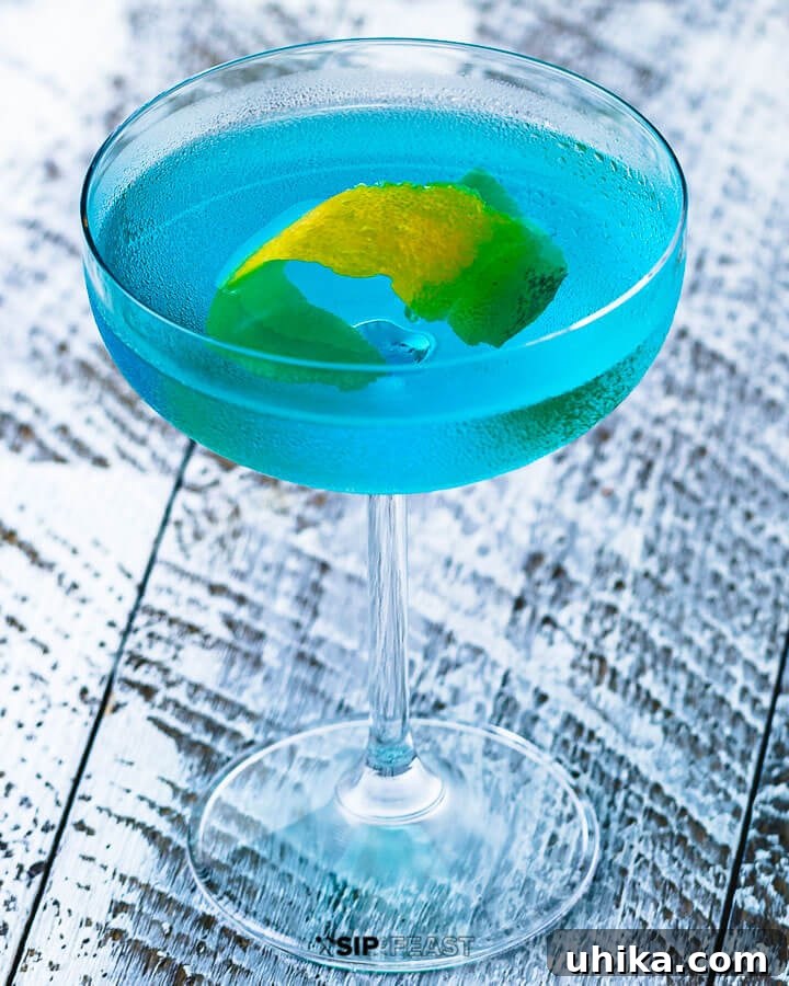 Coupe glass with angelo azzurro cocktail and lemon peel.