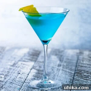 Angelo Azzurro cocktail in martini glass on grey table.