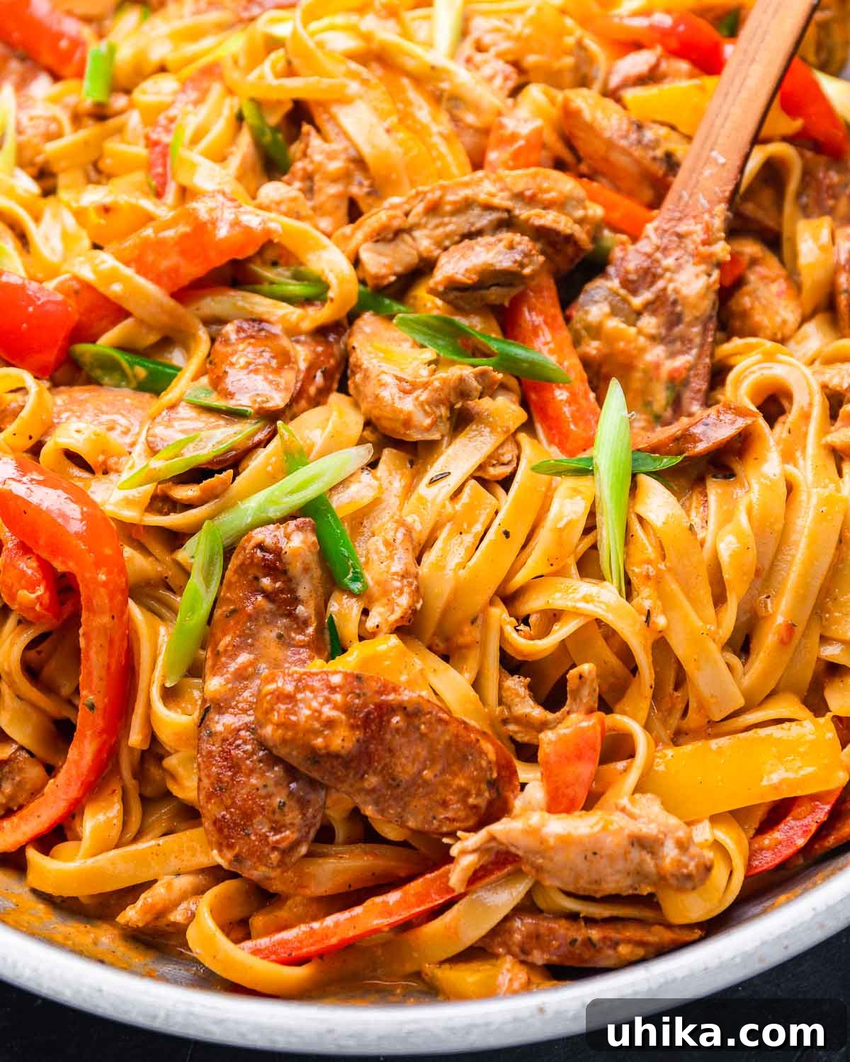 Spicy Creamy Cajun Chicken Pasta 8 Close-up of Cajun fettuccine pasta in a pan with generous pieces of Andouille sausage visible.