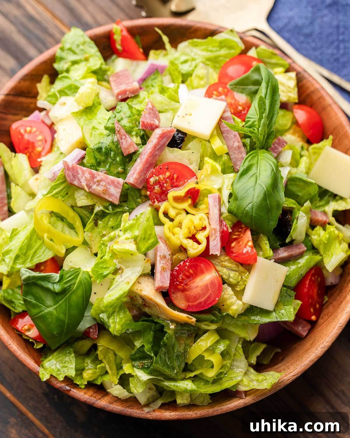 Italian Antipasto Chopped Salad 4 Rustic wood bowl filled with a fresh, vibrant Italian-style chopped salad, ready to be served.