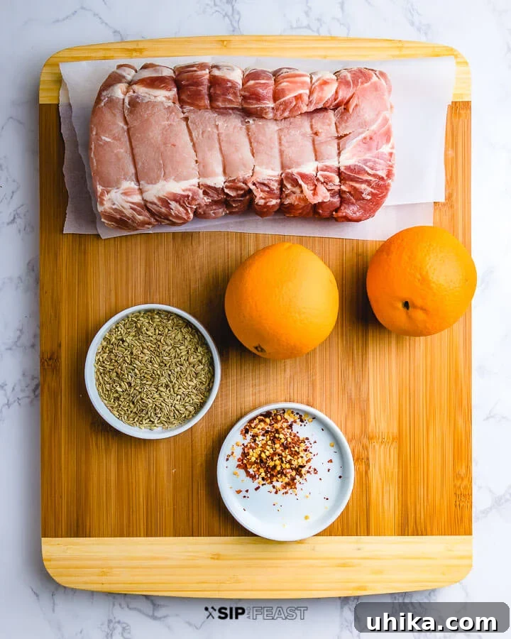 Ingredients shown: pork loin, oranges, bowl of fennel seeds and chili flakes on cutting board. Fresh ingredients for Instant Pot Italian Pulled Pork.