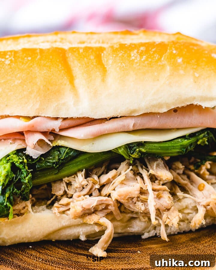 Closeup shot of shredded pork sub with broccoli rabe, provolone and mortadella. A mouthwatering close-up of an Italian pulled pork sandwich.