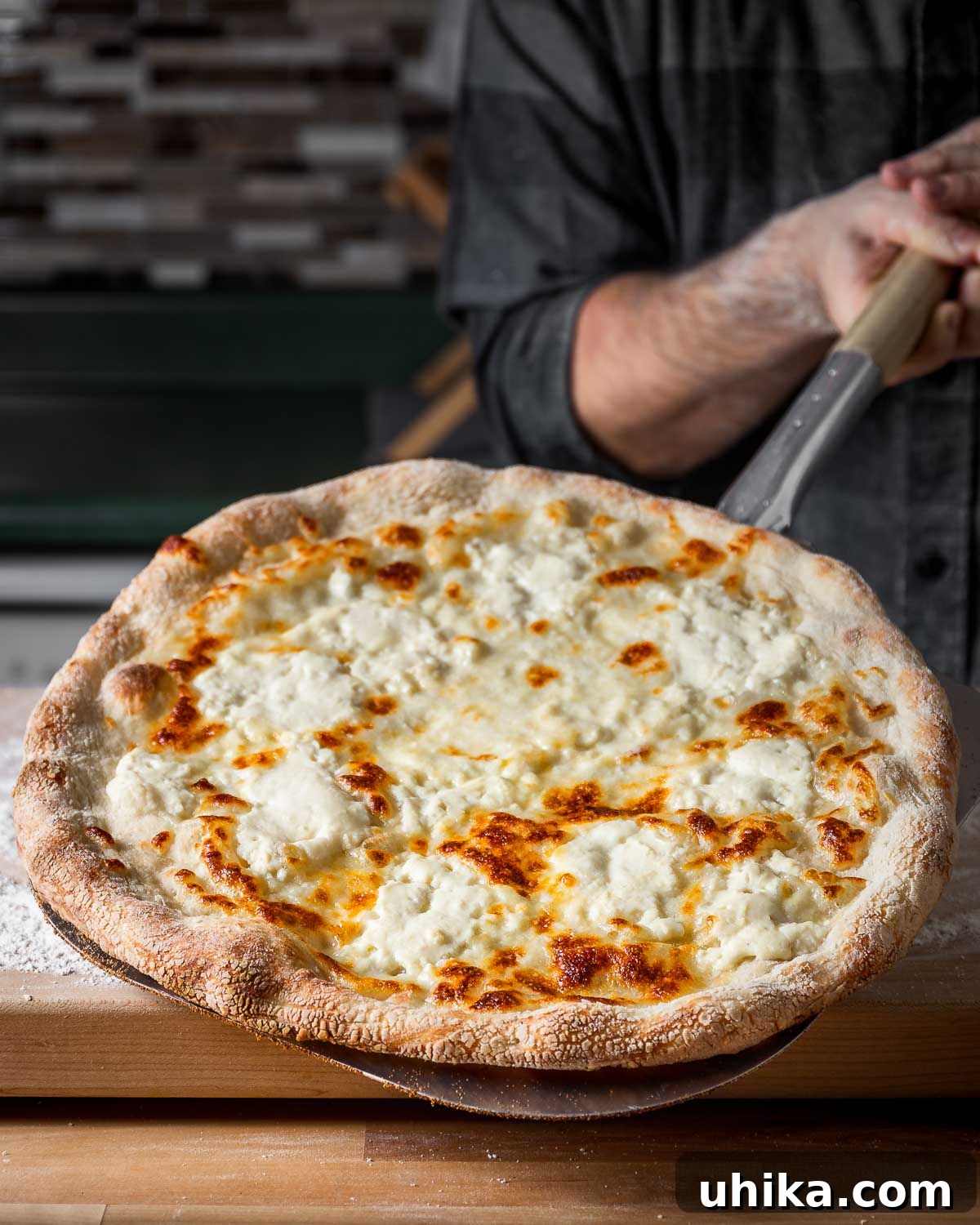 Creamy Garlic New York White Pizza 9 A full New York white pizza, still on the metal peel, showcasing the slightly grainy texture often seen when Galbani ricotta is used.
