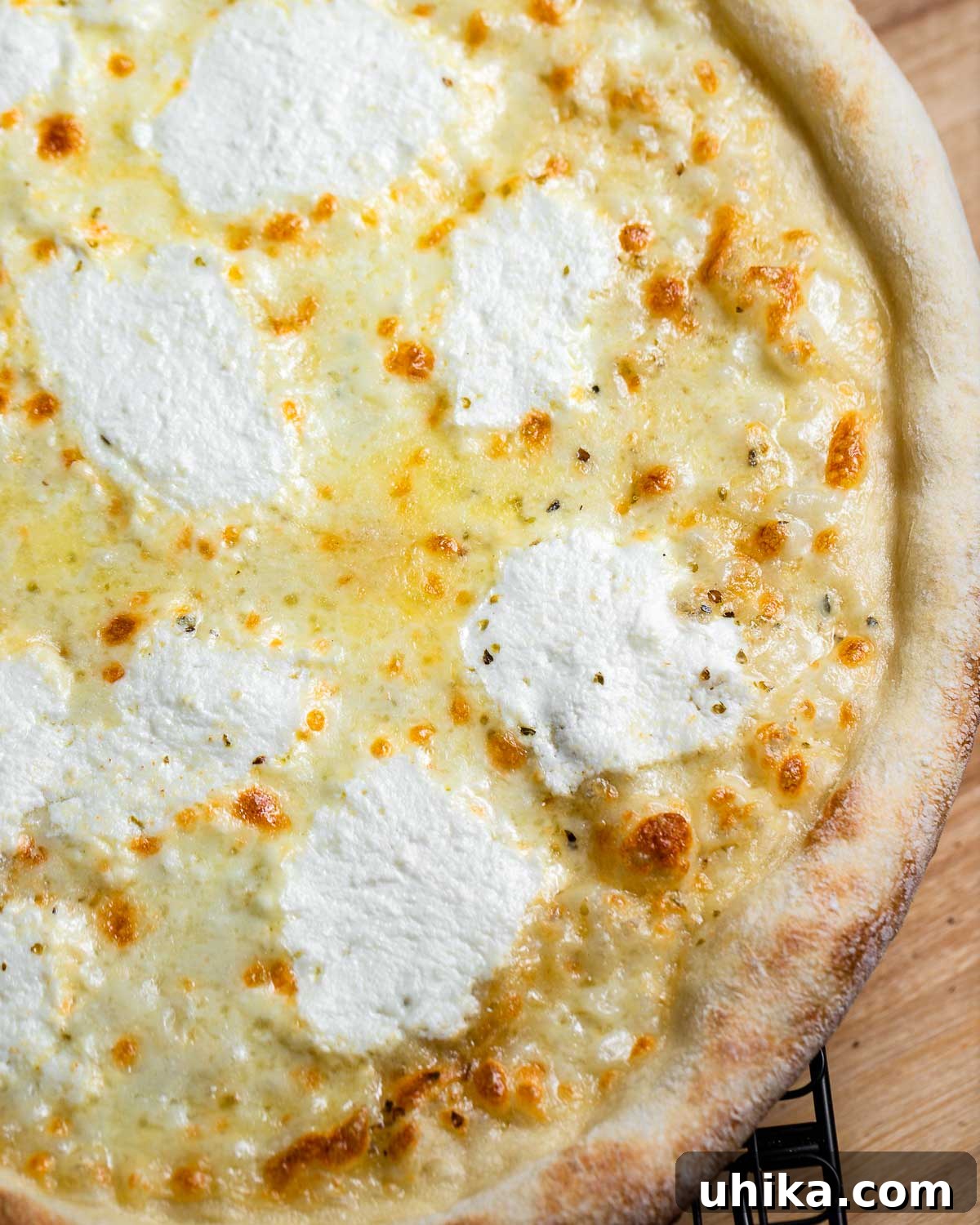 Creamy Garlic New York White Pizza 10 Another view of a freshly baked New York white pizza cooling on a wire rack, highlighting its perfectly cooked crust and melted cheese.