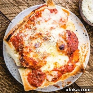 The Ultimate Meatball Parm Sandwich 2 A beautifully presented meatball parm hero in a white plate on a wooden table, ready to be enjoyed.