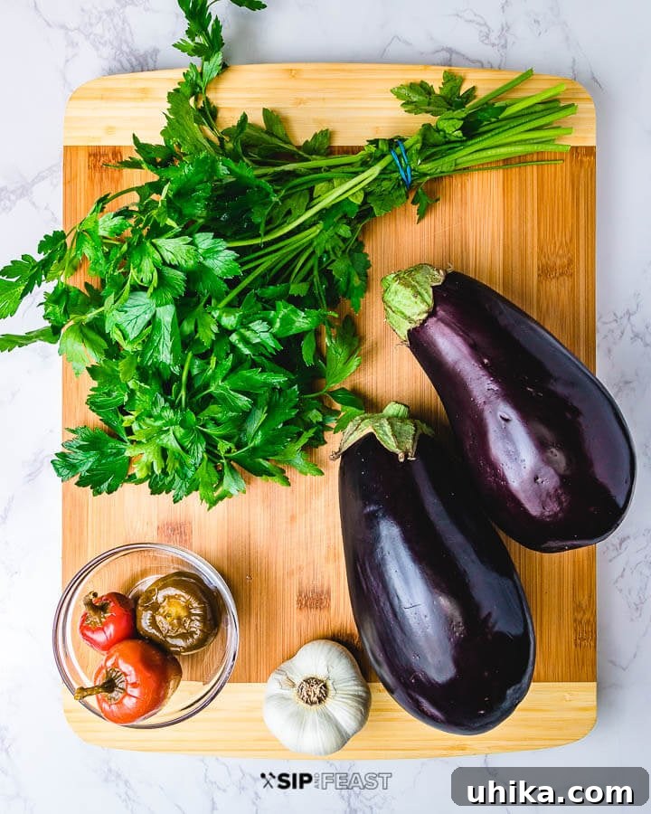 Key Ingredients for Melanzane Sott'olio: Eggplant, Garlic, Peppers, and Parsley Ingredients for Italian pickled eggplant laid out on a cutting board: fresh parsley, vibrant cherry peppers, pungent garlic cloves, and two large purple eggplants.