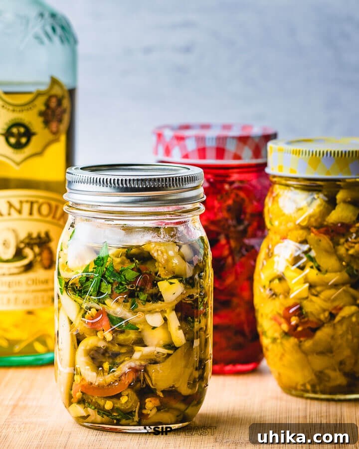 Artisanal Italian Pickled Eggplant: Three Jars Ready for Enjoyment Three jars of freshly made Italian pickled eggplant arranged neatly on a wooden cutting board.