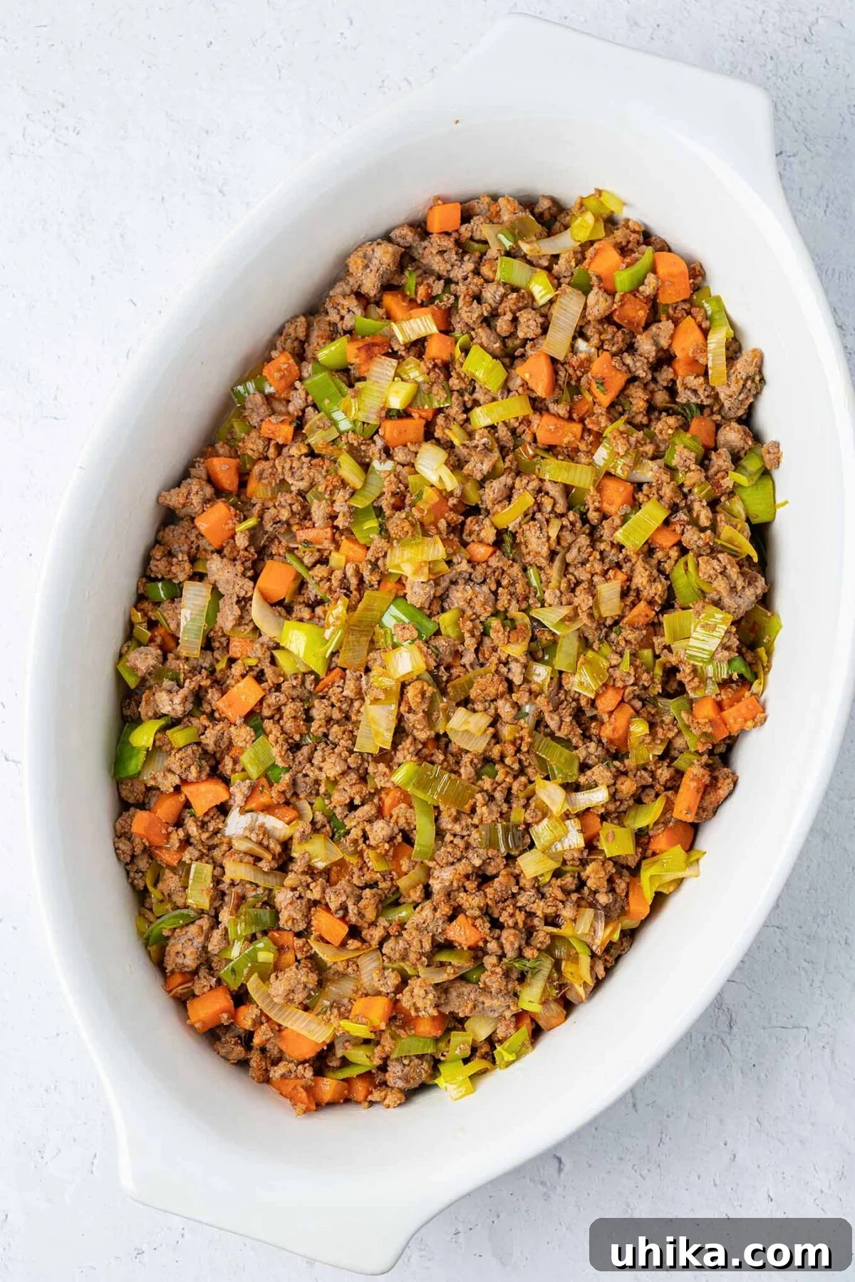 Hearty Lamb Shepherd's Pie 5 Ground lamb combined with sautéed leeks, carrots, garlic, and thyme, spread in the bottom of a casserole dish.