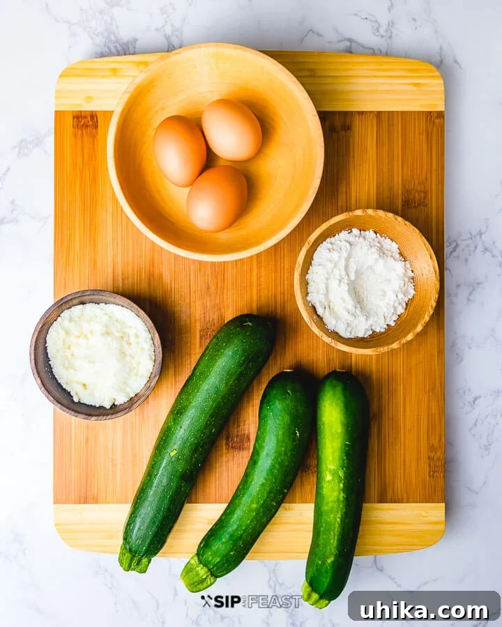 Zucchini Fritters - sipandfeast.com #zucchini #fritters #italian Ingredients shown: eggs in bowl, flour in bowl, cheese in bowl and 3 zucchini.
