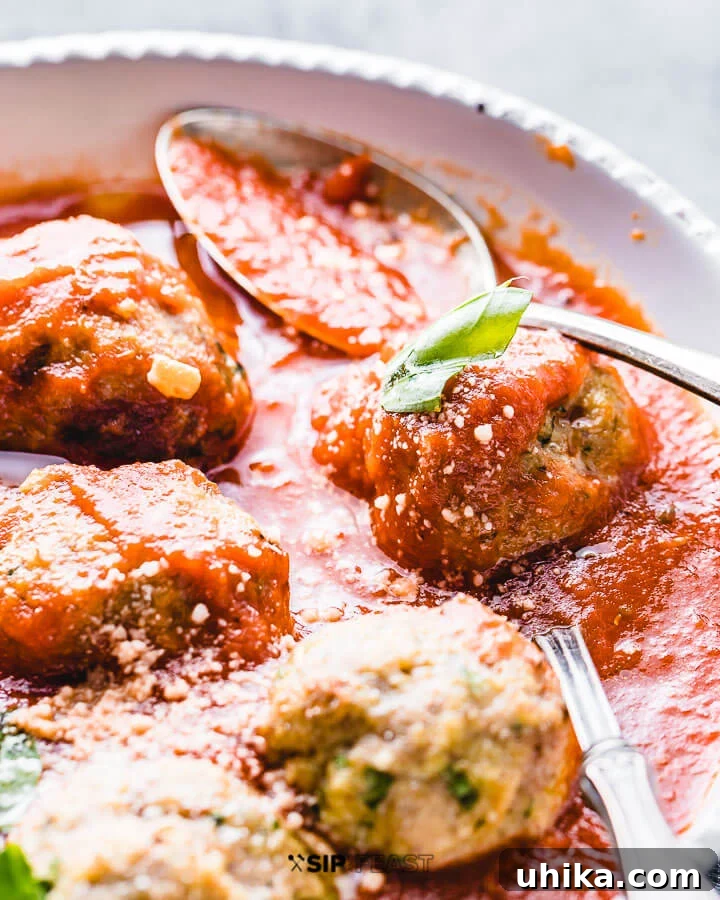Turkey meatballs with red sauce in a white bowl.