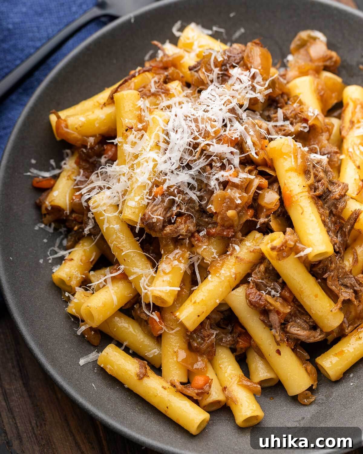Hearty Genovese Slow-Cooked Pasta 2 Pasta alla Genovese in grey plate with grated parmesan cheese.