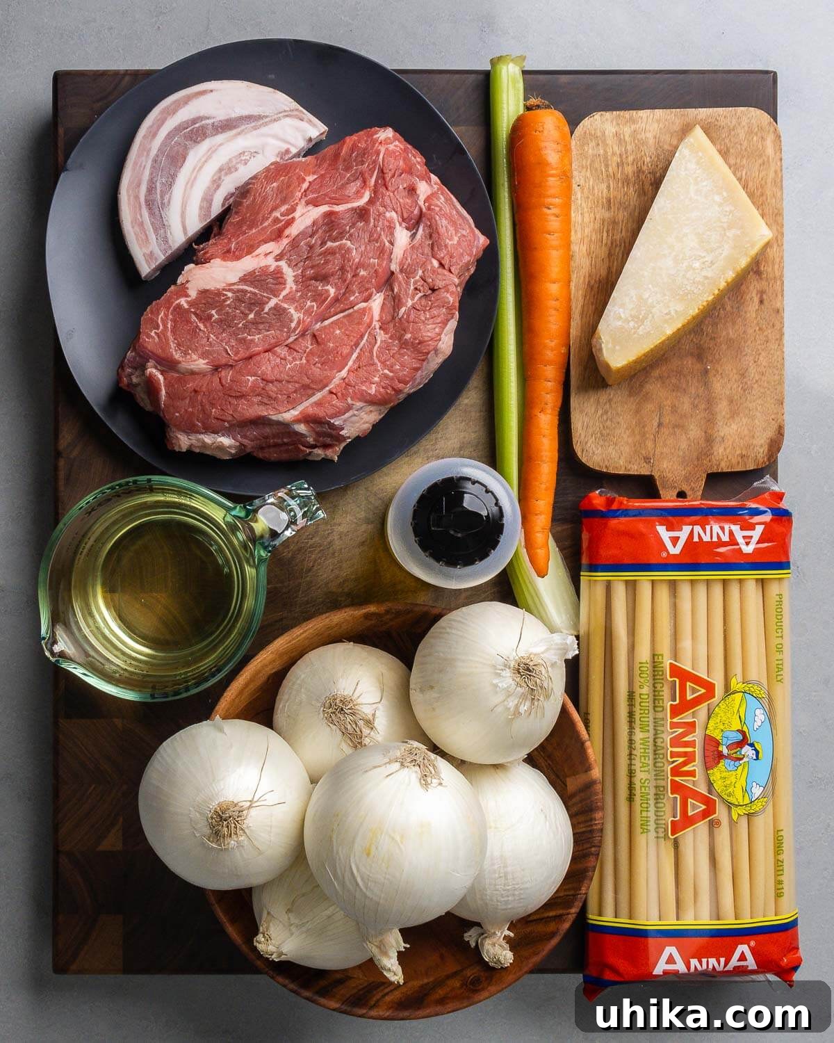 Hearty Genovese Slow-Cooked Pasta 3 Ingredients shown: pancetta, chuck roast, celery, carrot, Parmigiano Reggiano, white wine, olive oil, onions, and long ziti.