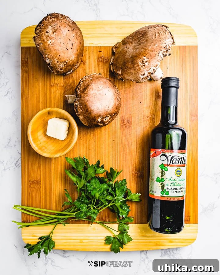 Sauteed Balsamic Portobello Mushrooms - sipandfeast.com #sidedish #italianfood #mushrooms Fresh ingredients laid out on a wooden cutting board, including whole portobello mushrooms, a stick of butter, fresh parsley sprigs, and a bottle of balsamic vinegar.
