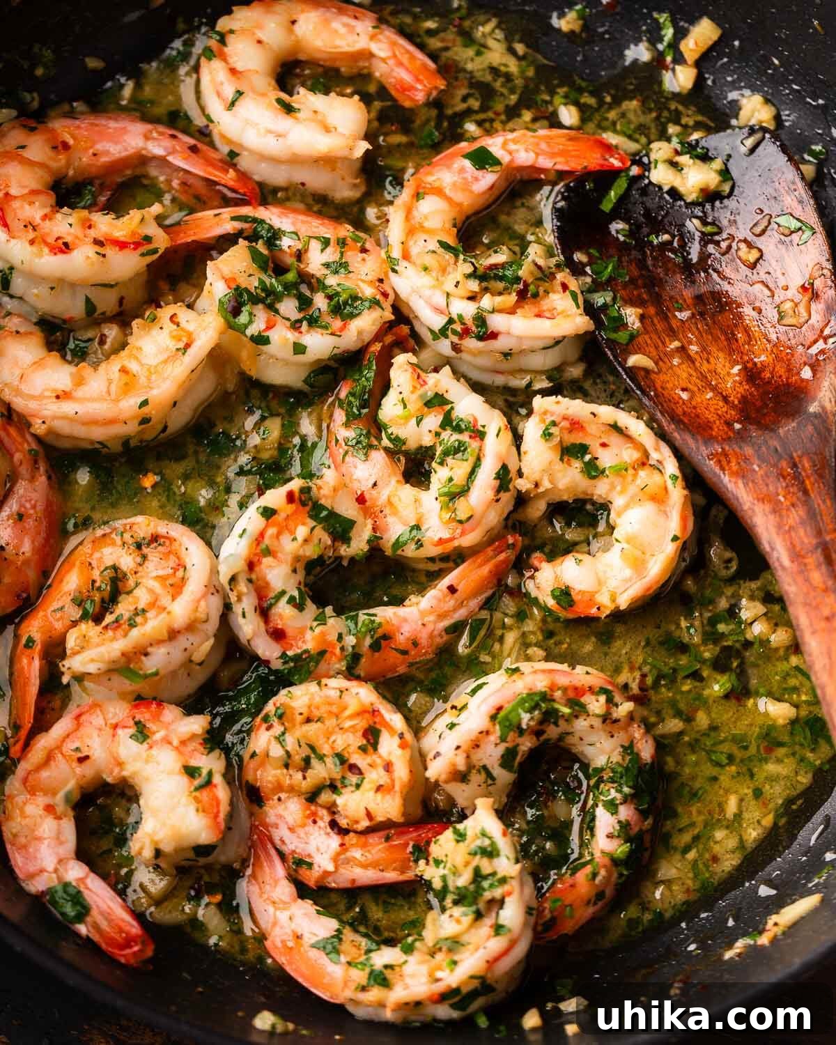 Effortless Garlic Shrimp Delight 2 Large black pan with perfectly cooked shrimp scampi, glistening in a golden garlic butter sauce, ready to be served.