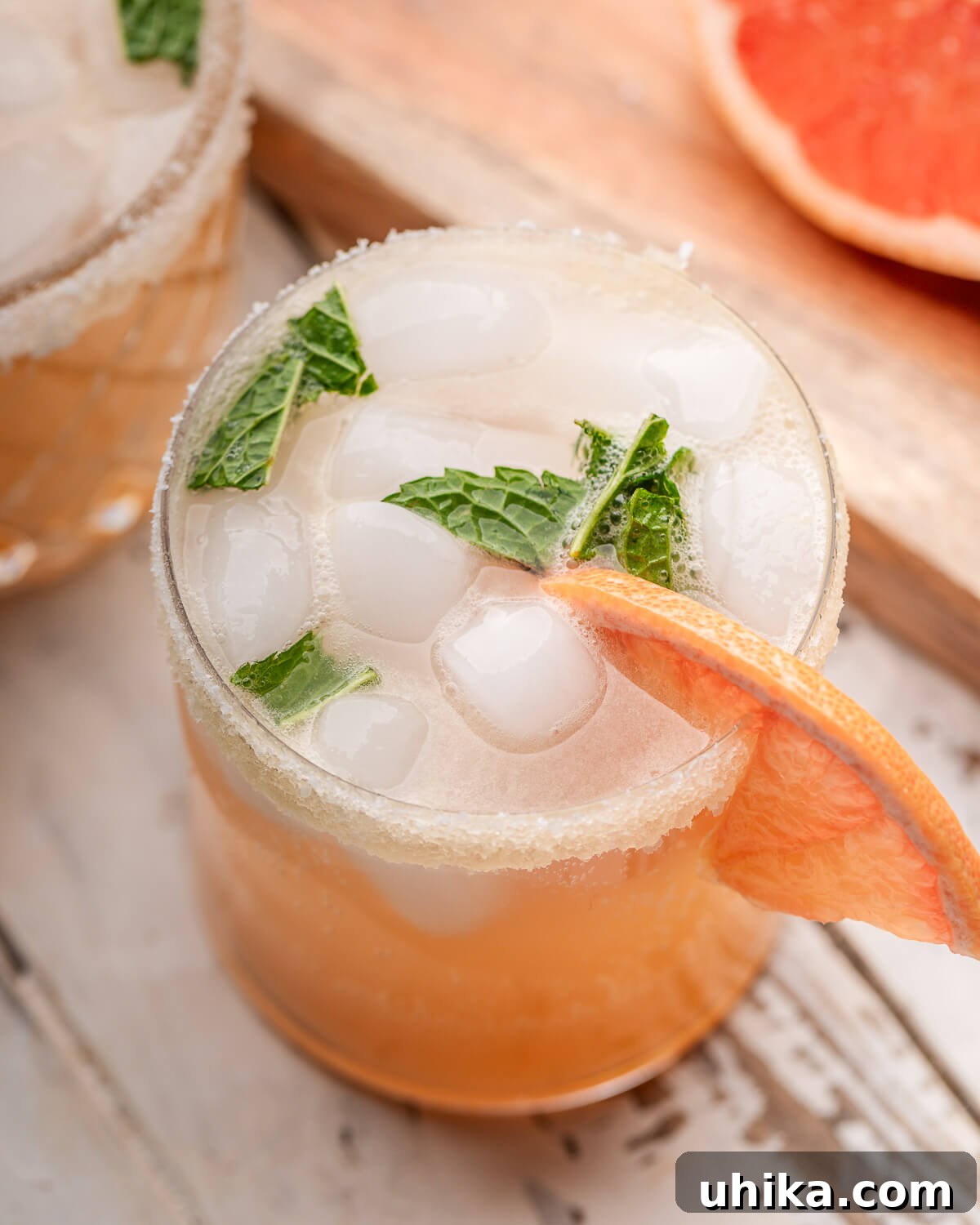The Minted Classic Paloma 4 An overhead shot showcasing a perfectly crafted Paloma cocktail, complete with a bright grapefruit wedge garnish, sitting ready to be enjoyed.