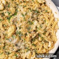 A pan filled with roasted cauliflower combined with pasta, toasted panko, pine nuts, and Parmesan cheese.