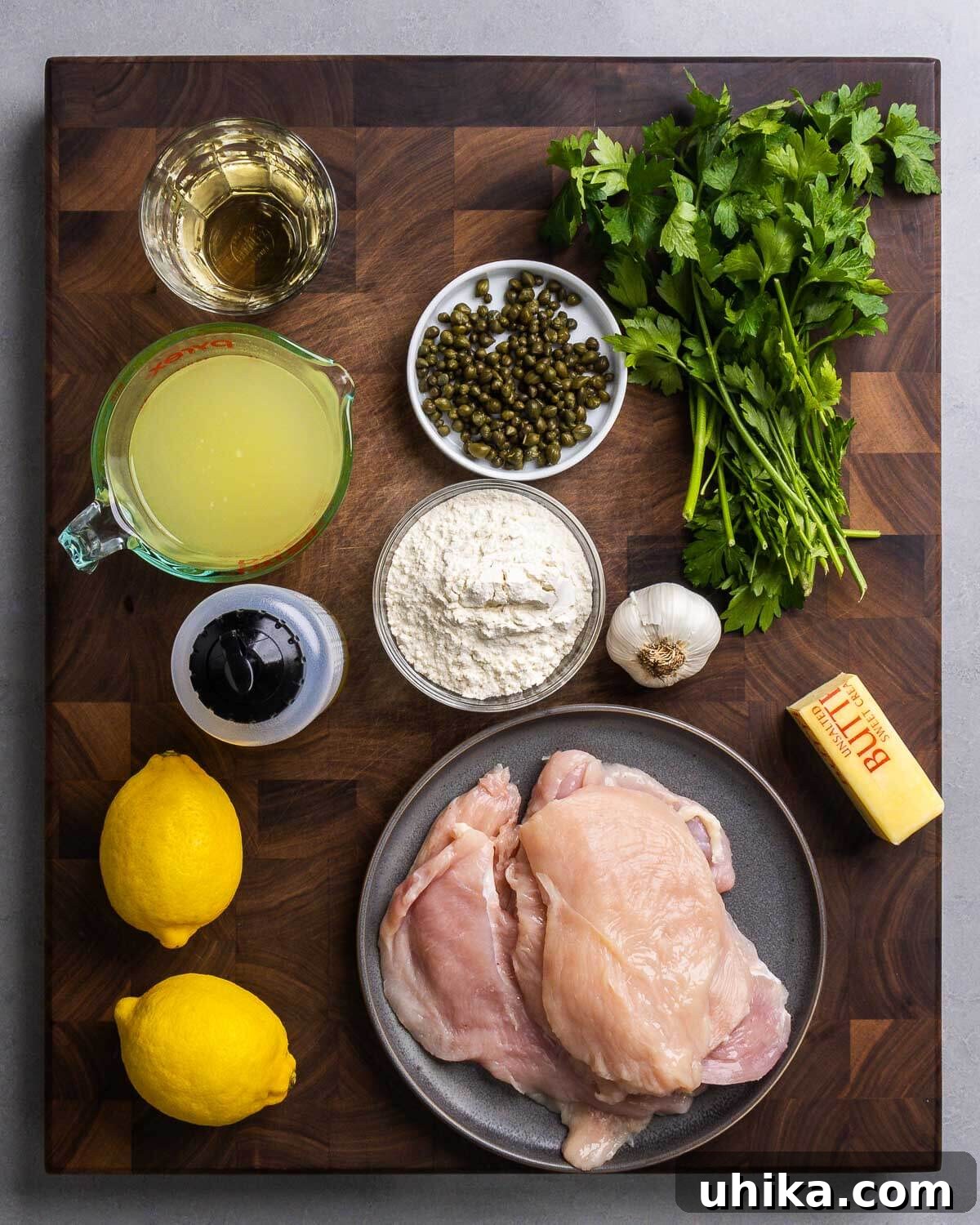 Zesty Lemon Caper Chicken 2 Ingredients shown: white wine, chicken stock, olive oil, capers, flour, parsley, garlic, lemons, chicken cutlets, and butter.