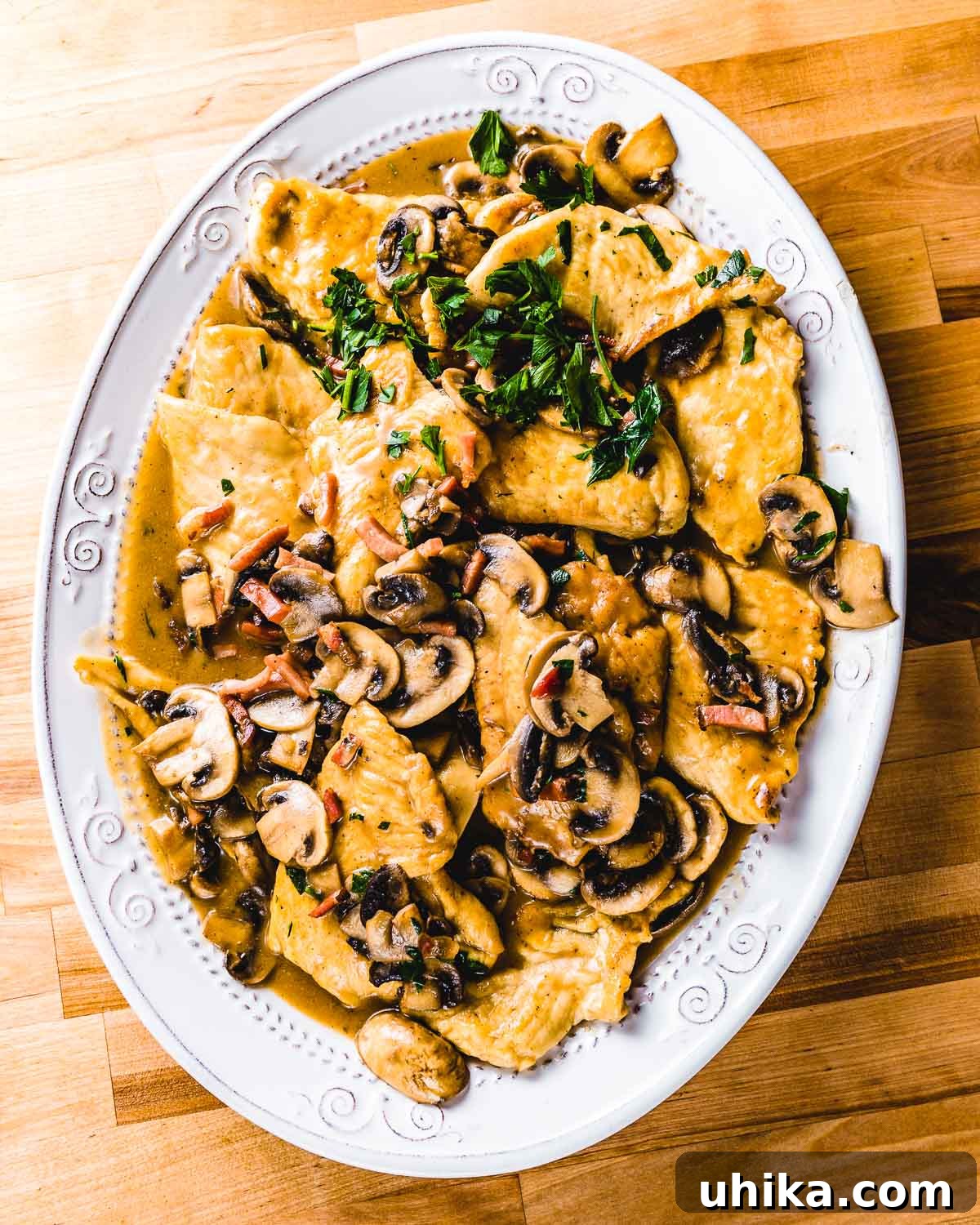 Plated Chicken Marsala Dinner A large white plate of savory Chicken Marsala, beautifully garnished with fresh parsley, presented on a rustic wooden table.