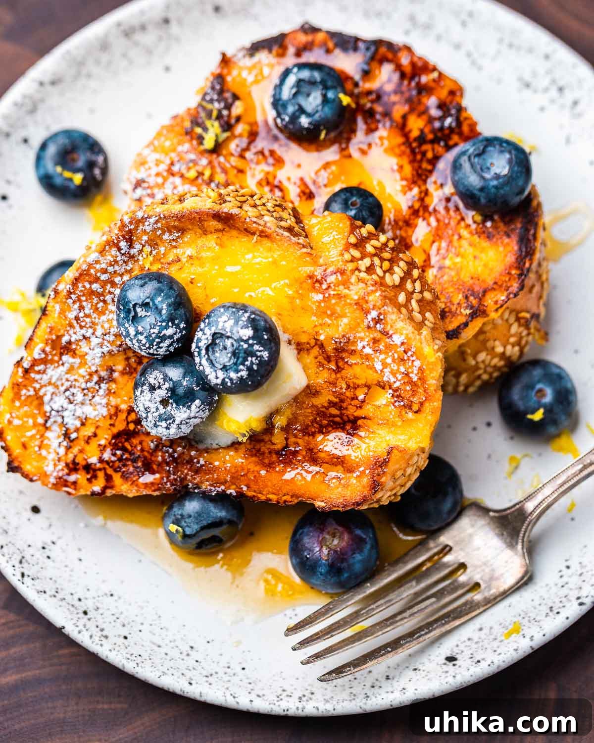 Dreamy Lemon Blueberry French Toast 6 A close-up shot of a single slice of Lemon Blueberry French Toast on a white plate, highlighting its golden edges and fresh berry topping.