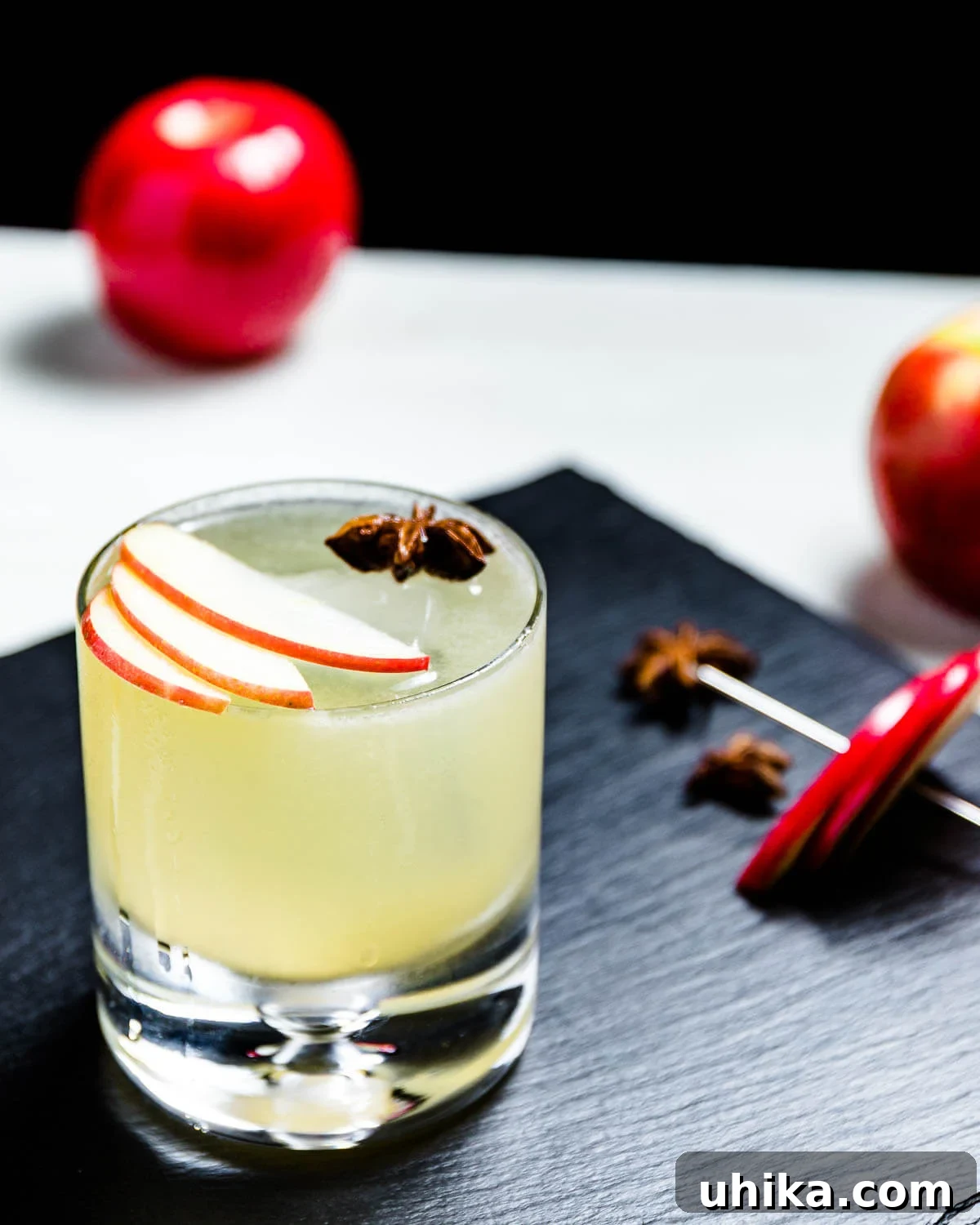 Apple margarita on black slate tile with apple in background.